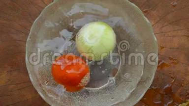 手把番茄和洋葱<strong>放到</strong>水中，溅到玻璃碗里